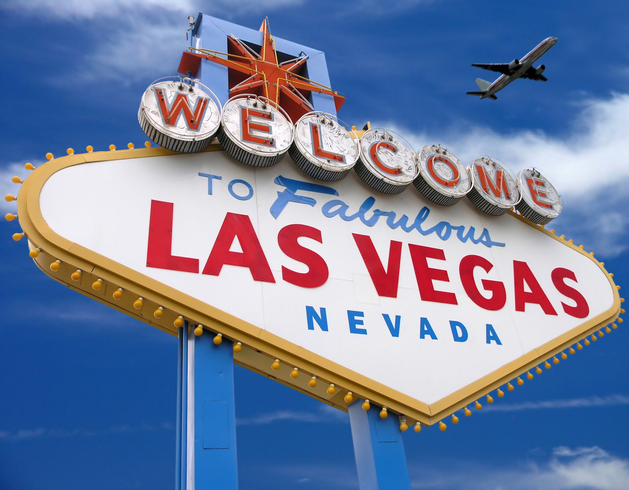 Welcome Sign To Las Vegas With Airplane In The Sky Stock Photo